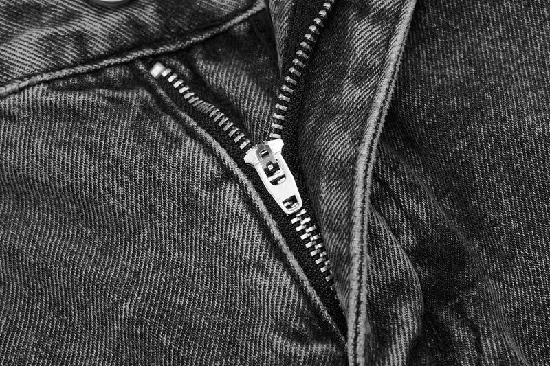 Close-up of front zipper on gray-black denim pants