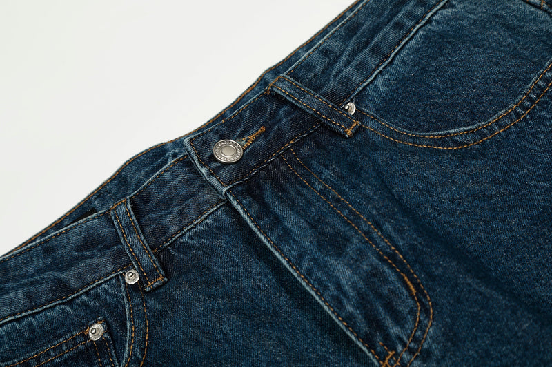 Close-up of the front waistband and button on deep indigo cotton denim