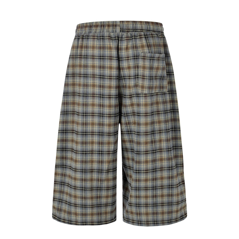 Back view of oversized plaid lounge shorts with elastic waist and single rear pocket