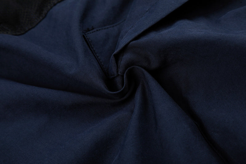 Close-up of navy cargo pants fabric fold with smooth woven texture