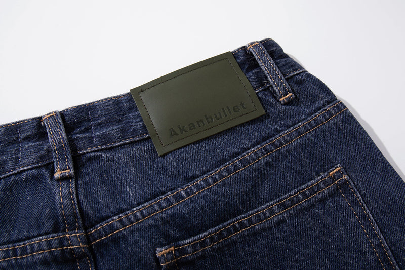 Close-up of back waistband showing the green label patch and topstitching