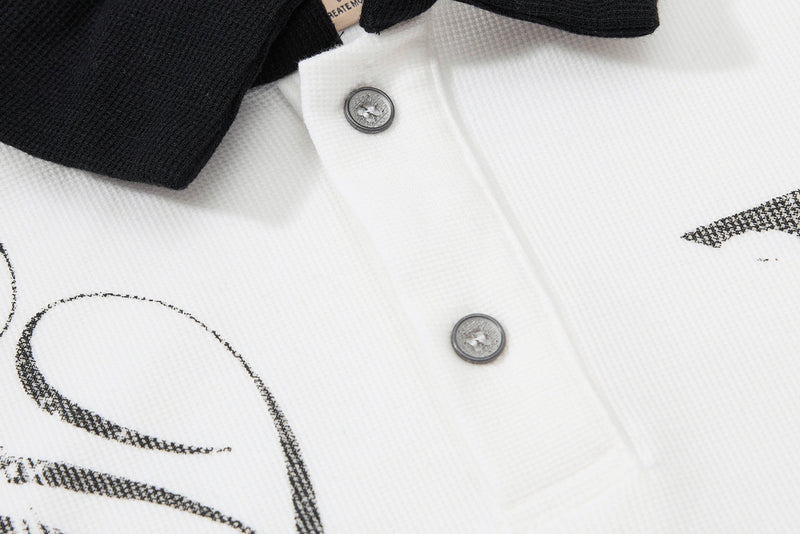 White gothic polo shirt with black contrast collar, skull graphic detailing, and silver buttons on textured fabric