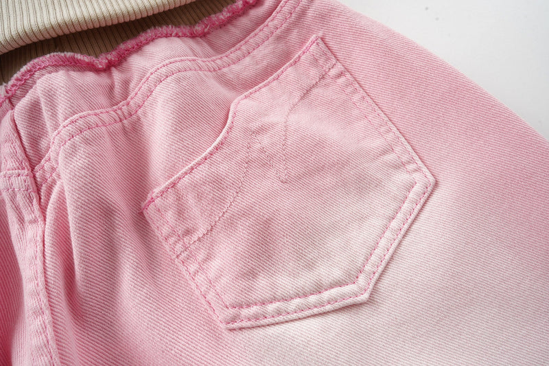 Close-up of pink back patch pocket on washed wide-leg jeans