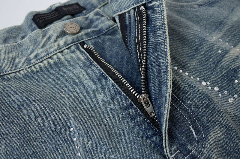 Close-up of light wash denim shorts front zipper and waistband button