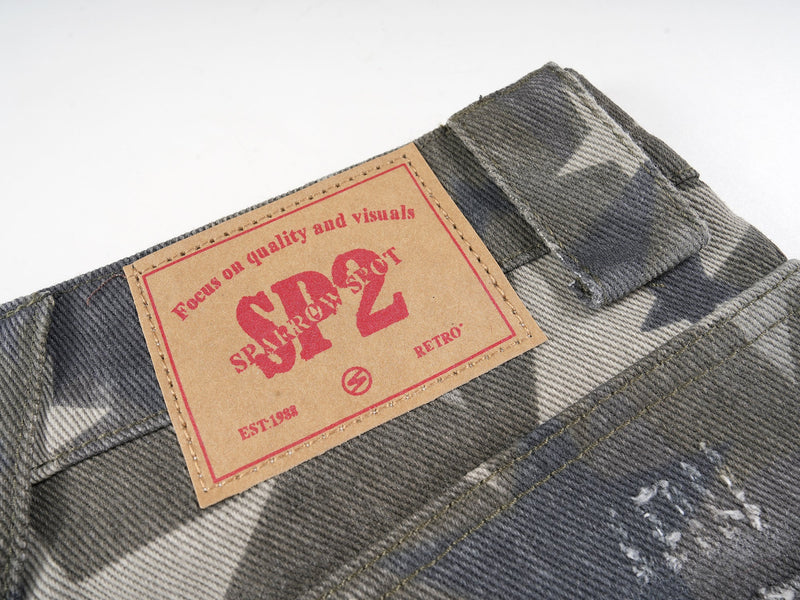 Leather logo patch on waistband of gray star print denim pants
