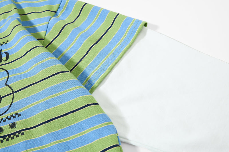 Close-up of striped sleeve and layered white long-sleeve underneath