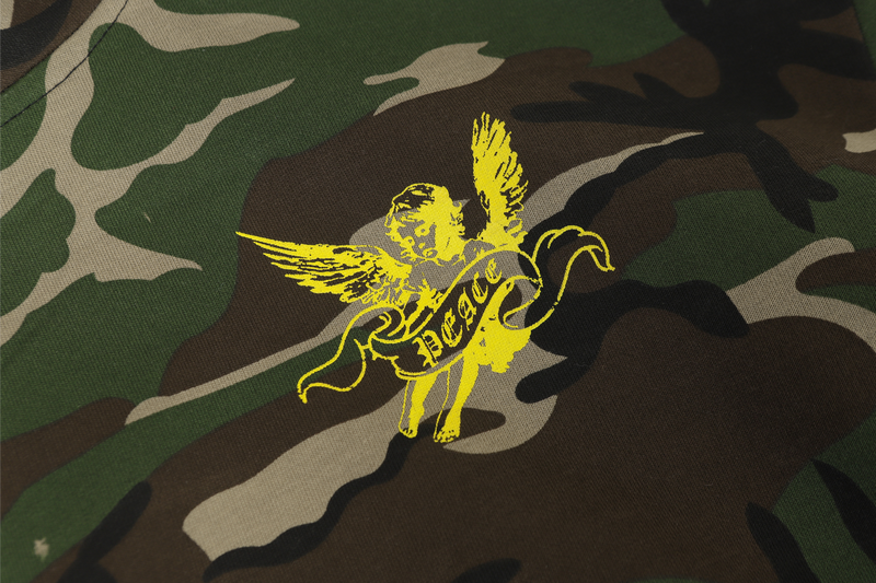 Small yellow angel graphic printed on camo fabric close-up