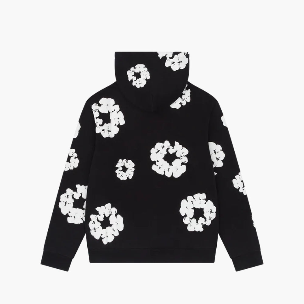 The Black “Cotton Wreath” Denim Tears Hoodie features a white floral ring print, blending bold streetwear design with comfort.