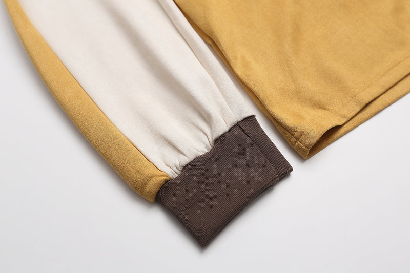 Close-up of the sleeve cuff and side seam on the mustard rugby top