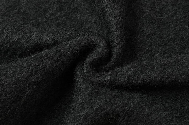 Close-up of the dark wool-blend fabric showing a soft, fuzzy textured weave
