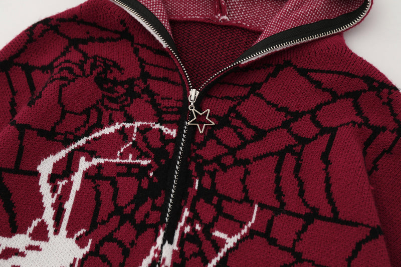 Close-up of burgundy zip hoodie chest, star zipper pull, and spiderweb knit pattern