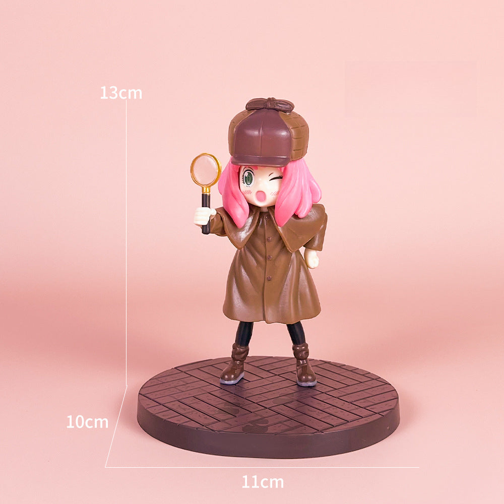 The Detective Anya PVC Figure Set from Spy × Family features a 14cm tall figure in a brown coat and hat, with pink hair and one eye winking. It includes a magnifying glass and stands on a round base. This movie version offers four poses.