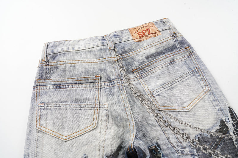 Close-up of the back waist and pockets on light wash denim with chain detail and logo patch