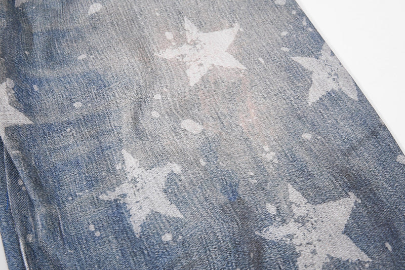 Close-up of faded blue denim leg with white star print