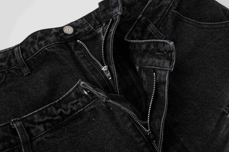 Close-up of black denim layered waistband with zipper fly and belt loops