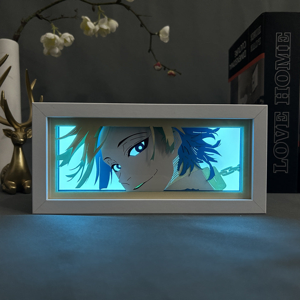 The Bleach Grimmjow Anime Light Box is a 3D LED lamp featuring an illuminated image of Grimmjow Jaegerjaquez with blue hair and a neutral expression. The background emits a soft glow, while a decorative deer figurine and flower branch are subtly visible.