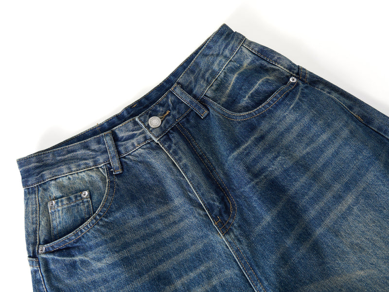 Close-up of jeans waistband and front pocket with button closure and faded denim texture