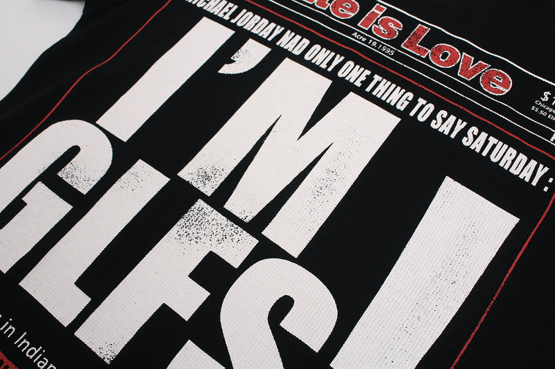 Black streetwear T-shirt with bold newspaper-style HATE IS LOVE graphic and red headline accents