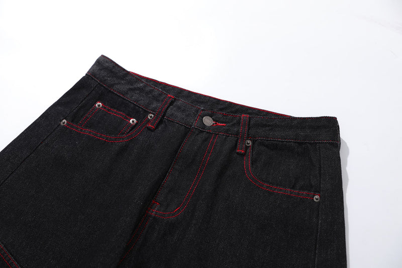 Close-up of front waistband and left pocket on black jeans with red stitching