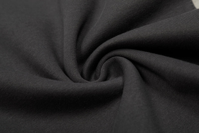 Close-up of black cotton tee fabric with soft textured knit and draped folds