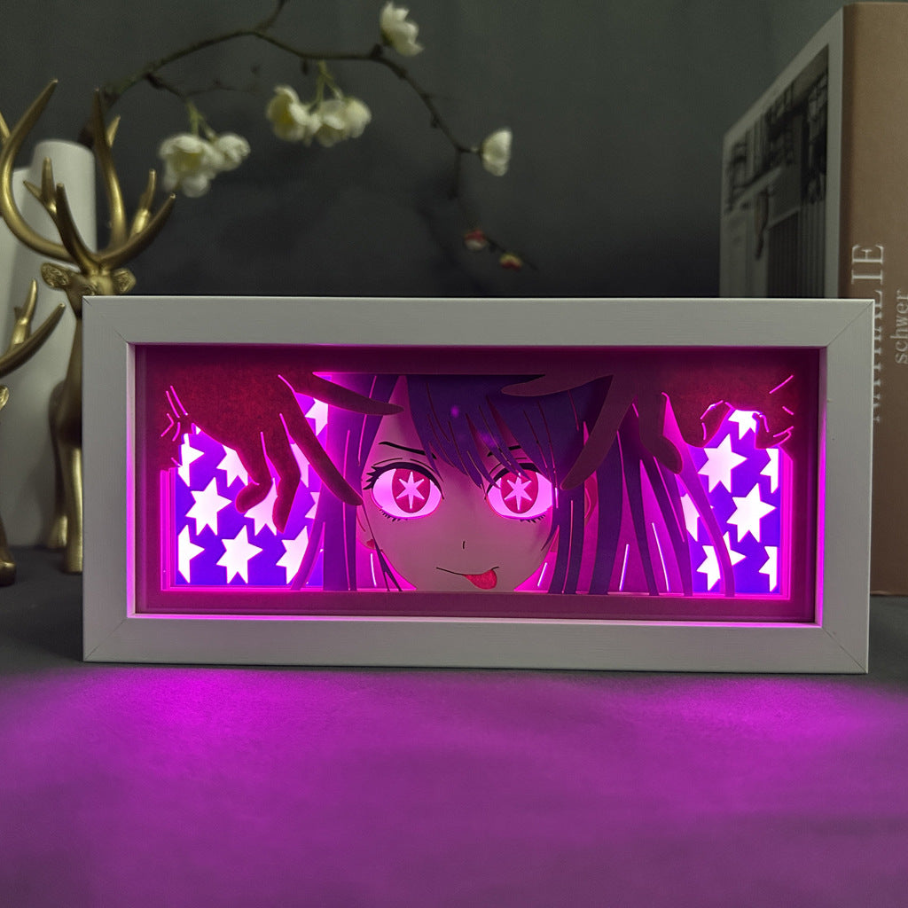 The Seakoff Oshi no Ko Ai Hoshino Anime Light Box showcases Ai Hoshino with starry eyes and a mischievous expression, backlit by pink and purple lights. Glowing stars fill the background, complemented by decorative antlers and white flowers for an enchanting scene. Includes 16 colors &amp; remote control.