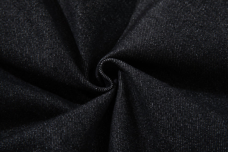 Close-up of black denim fabric texture gathered in folds