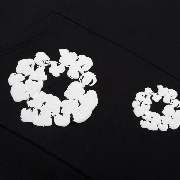 The Black "Cotton Wreath" Denim Tears Hoodie features white floral ring prints resembling popcorn-shaped clusters for a standout streetwear look.