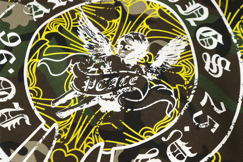 Close-up of circular angel graphic with white and yellow print on camo fabric