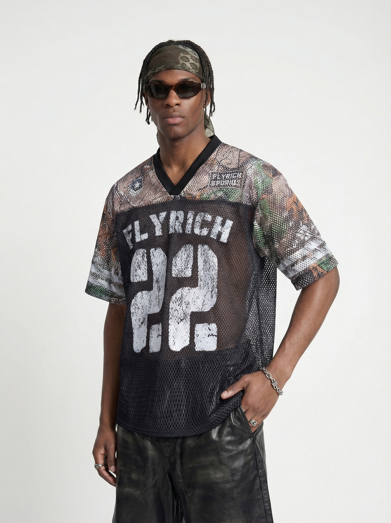 Model wearing a Seakoff Fly Rich 22 camo mesh jersey T-shirt with black V-neck and streetwear styling