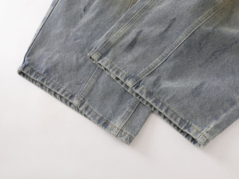 Close-up of the wide hem on faded blue denim pants with straight stitched cuffs