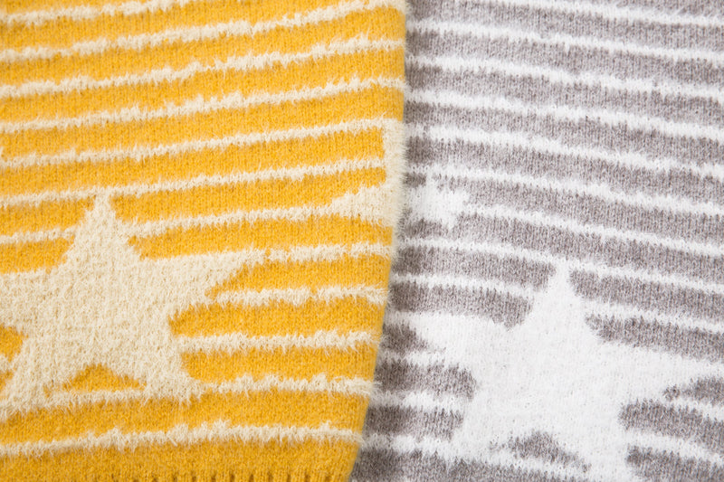 Close-up comparing yellow and gray striped knit fabric panels with a star motif