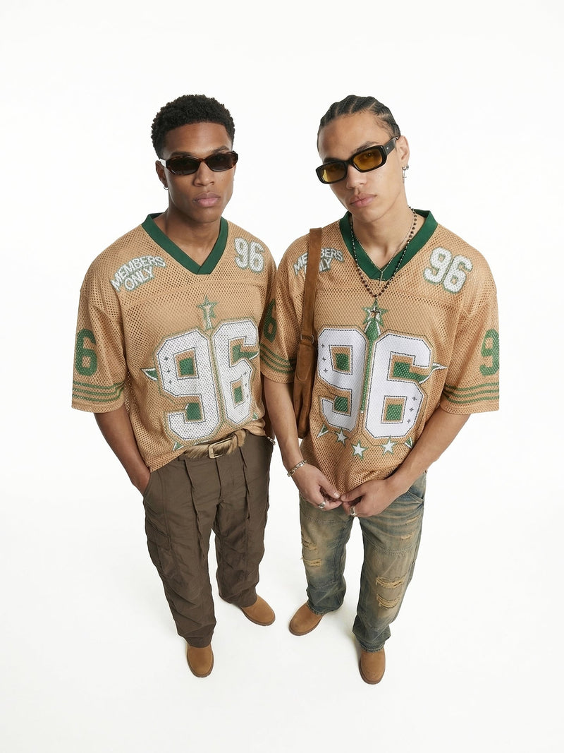 Two models wearing tan Seakoff 96 mesh jersey streetwear shirts with green trim and vintage graphic details