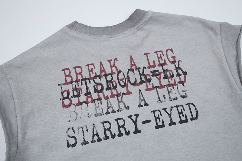 Grey sleeveless distressed T-shirt with layered distressed text graphic reading Break a Leg and Starry-Eyed on the back