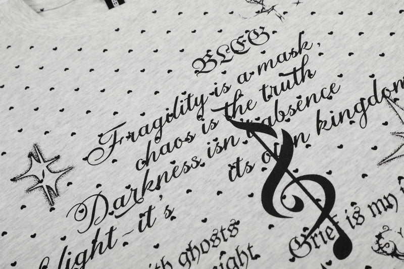 Gray graphic tee with allover black micro-print script, polka dots, and bold treble clef design in relaxed streetwear style