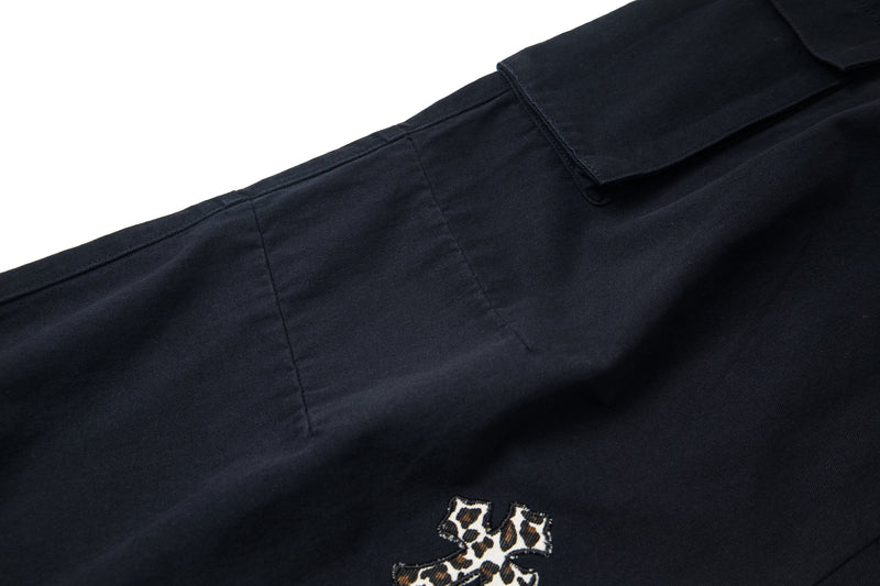 Black cargo pants leg with leopard cross patch and cargo pocket flap