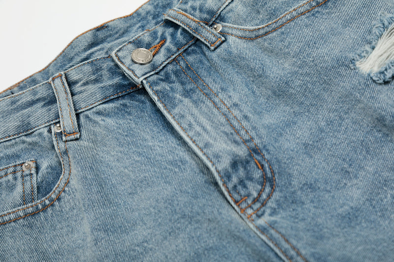 Close-up of front waistband on light blue distressed denim shorts with button fly and belt loops