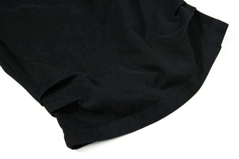 Close-up of black shorts leg hem showing smooth cotton fabric and stitched edge