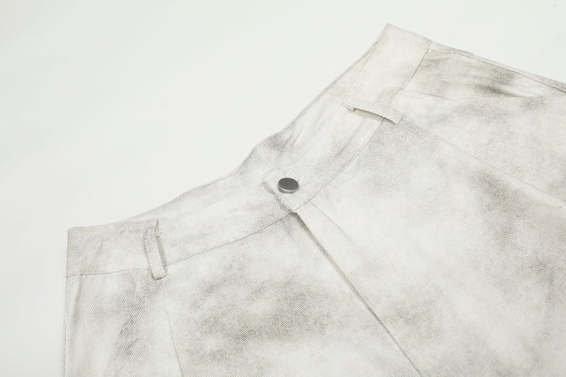 Close-up of the waistband and metal snap button on white washed cargo pants
