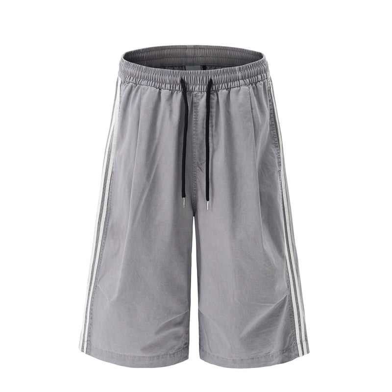 Front view of gray wide-leg shorts with elastic waistband, black drawstring, and side stripes