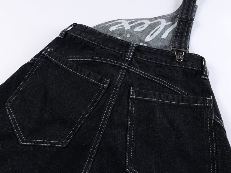 Close-up of black jeans back waistband and gray printed lining with strap hardware