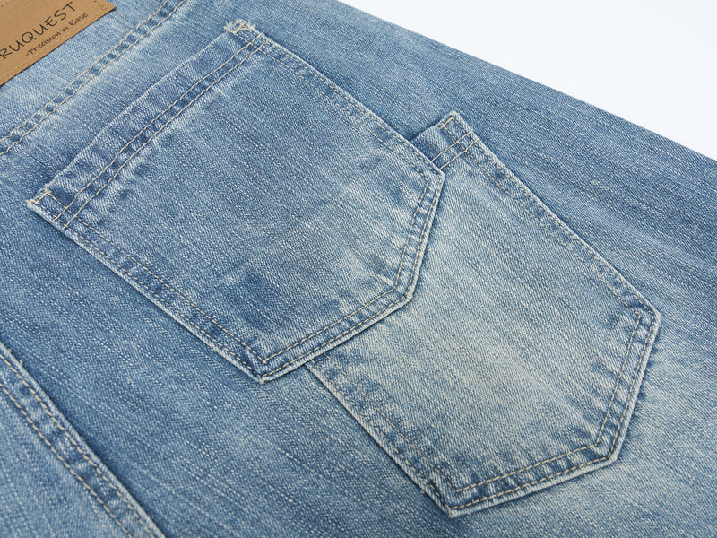 Close-up of back pocket on light blue washed denim jeans with contrast stitching