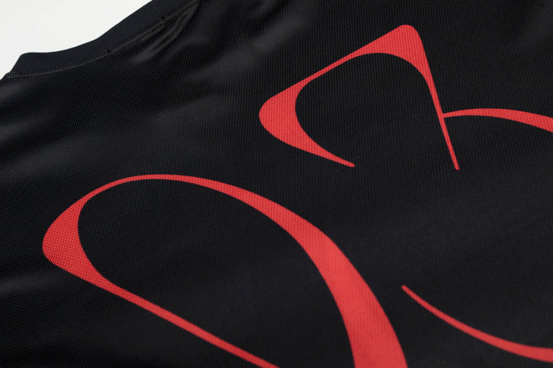 Black mesh jersey with bold red abstract portrait graphics and a ribbed crew neckline, shown in close-up