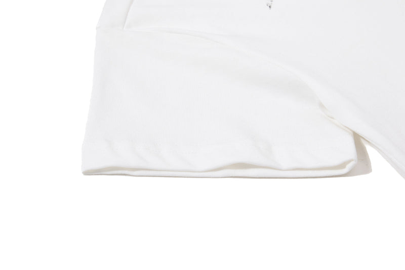 Close-up of a white cotton polo tee hem with subtle ribbed texture and clean streetwear styling