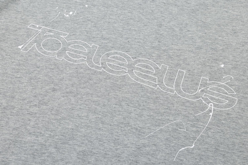 Close-up of light gray front logo print on the layered long sleeve tee
