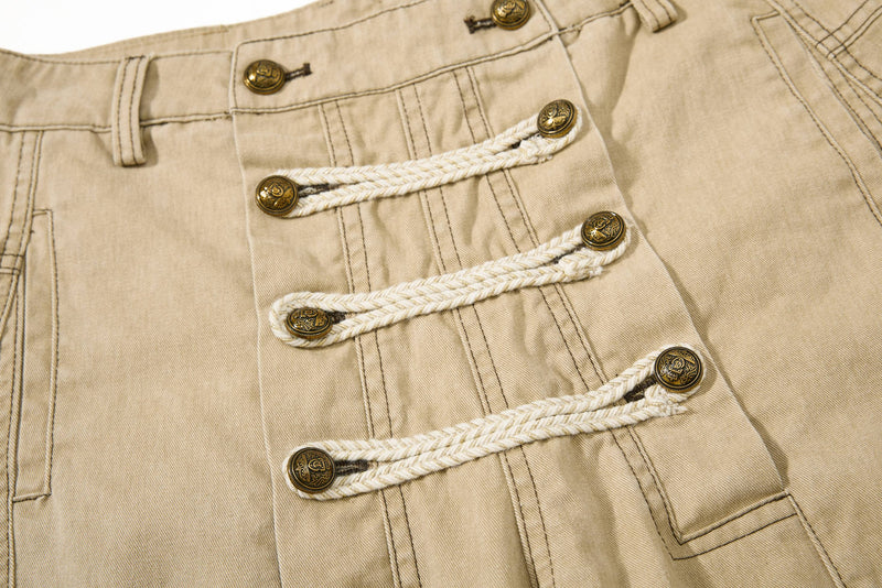 Close-up of khaki pants front with braided rope closures and brass button details
