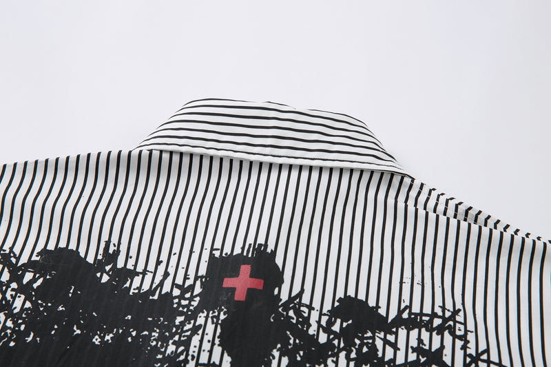 Back collar close-up of striped shirt with black graffiti print and a small red cross graphic