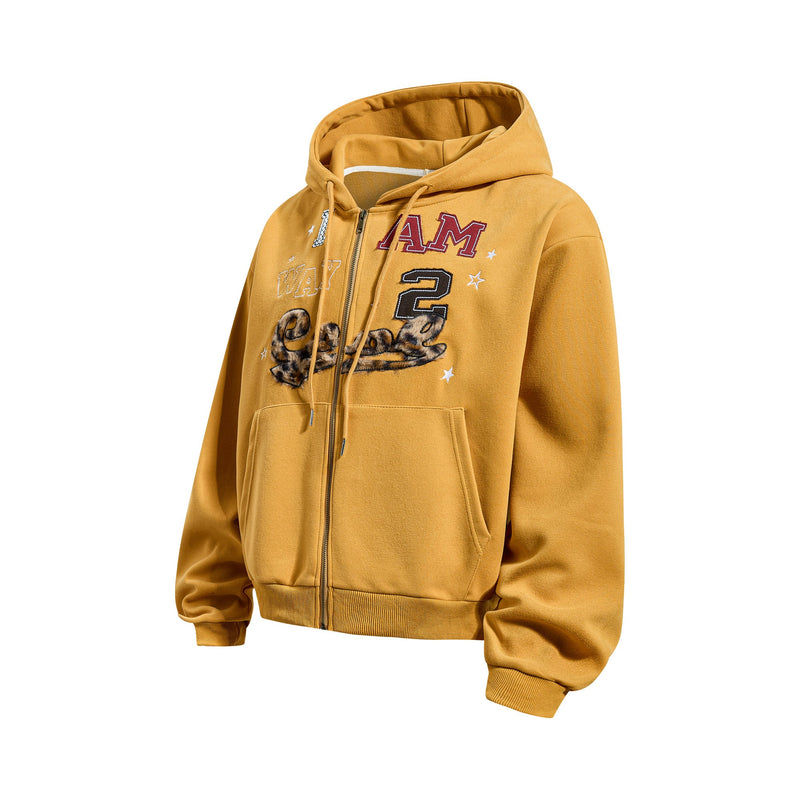 Three-quarter front view of mustard yellow zip-up hoodie with chest graphic and kangaroo pockets
