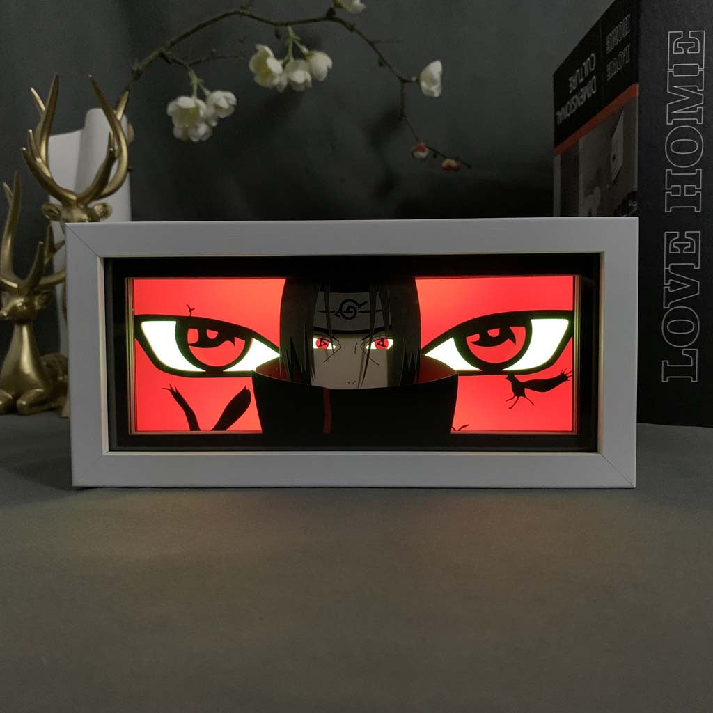 The Naruto Itachi Uchiha LED 3D Light Box – Sharingan Eternal Mangekyou Design showcases a vivid character with red and black eyes on a bright red background, featuring decorative branches, white flowers, and an antler ornament, perfect for fans of Itachi Uchiha.