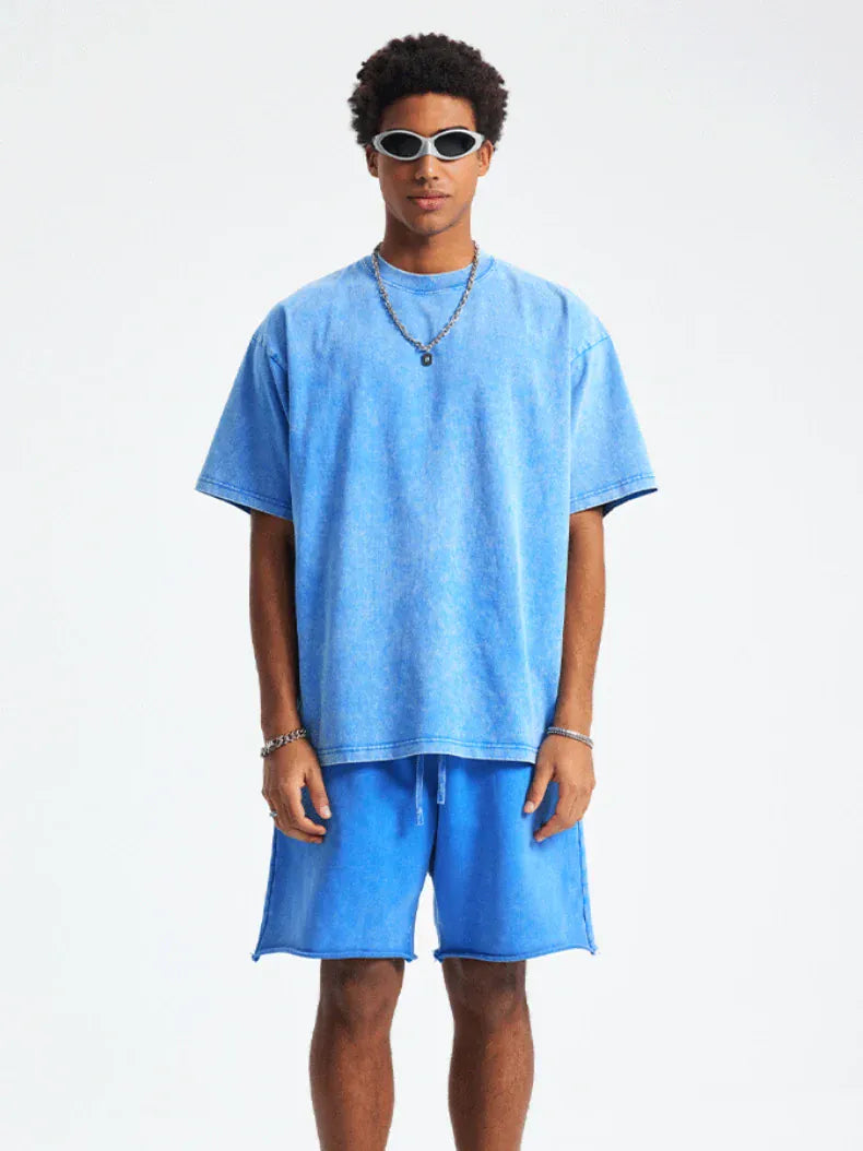 A man faces forward against a plain white background, wearing the Custom Anime Character Blue Washed T-Shirt - Personalized Anime Style Tee, matching blue shorts, sunglasses, and silver jewelry.