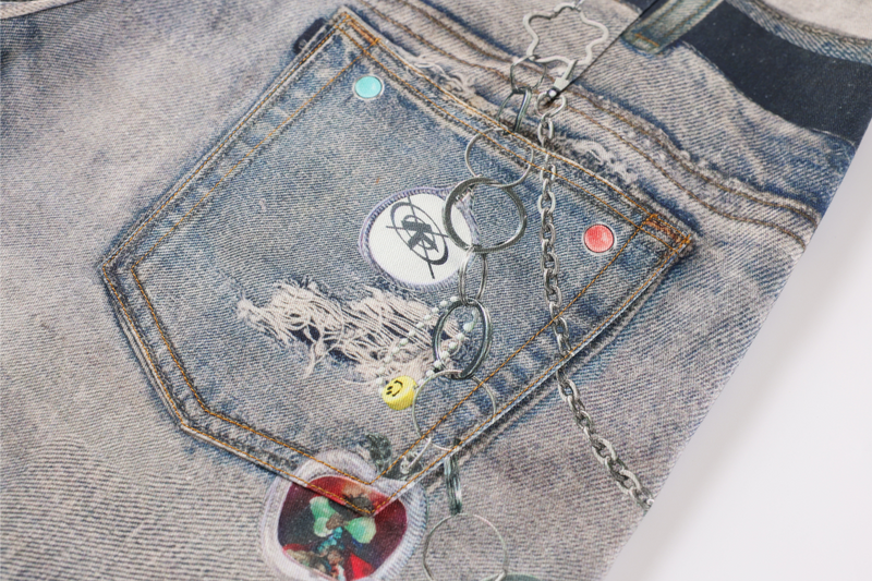 Back pocket close-up with chain and charm details on faded patchwork denim
